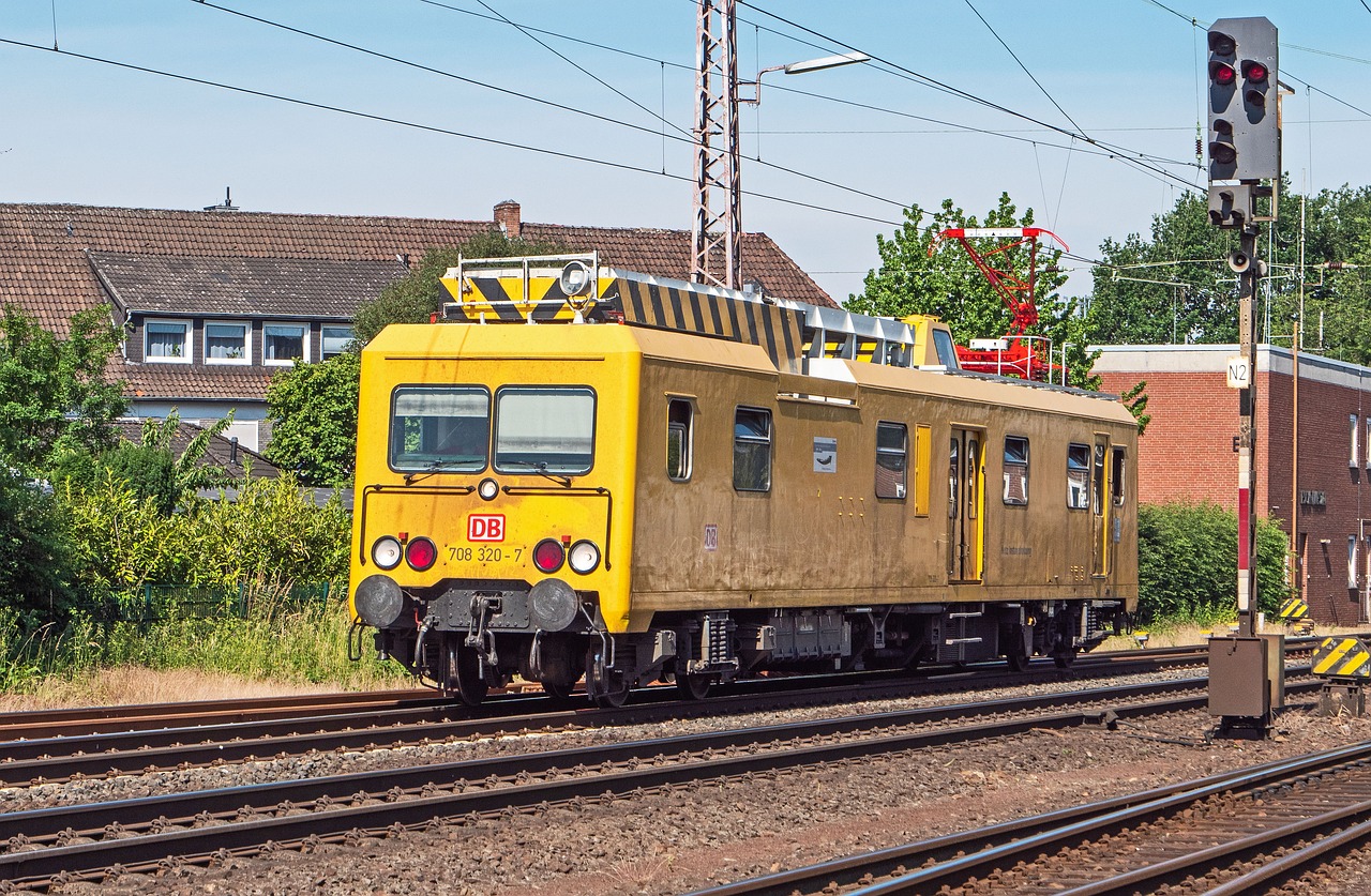 Véhicule de service ferroviaire jaune circulant sur une voie